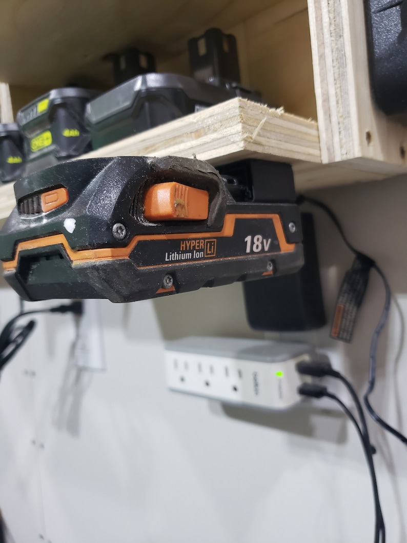 May include: A black and orange 18V lithium-ion battery charger with the text "HYPER Li" and "Lithium Ion" on it.