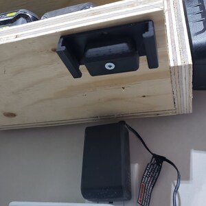 May include: A close-up of a black power strip with a white power cord plugged into it. The power strip is labeled "belkin" and "Protected".