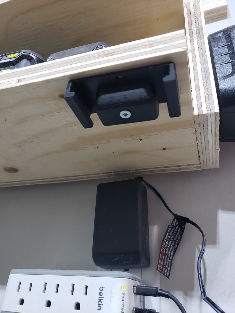 May include: A close-up of a black power strip with a white power cord plugged into it. The power strip is labeled "belkin" and "Protected".