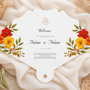 Puede incluir: Una tarjeta de programa de boda en forma de abanico blanco con un icono de Ganesha dorado en la parte superior, ilustraciones florales en rojo, naranja y amarillo a los lados, y texto negro que dice Welcome to the wedding of Name & Name, 23.09.2026.