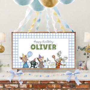 May include: A framed print with a blue and white gingham border features the text "Happy Birthday OLIVER" above cartoon animal characters. The animals include a mouse, cat, pig, dog, and moose, all wearing party hats. Balloons and streamers decorate the top.