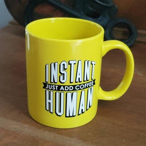 May include: Yellow ceramic mug with a black and white graphic that reads "Instant Just Add Coffee Human".