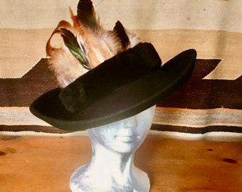 Wool felt bowler style had with rolled brim hat band is vintage mouton  feather are assted rooster and wild bird OS fits all