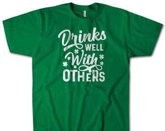 Drinks Well With Others T-Shirt, Funny Festive St. Patrick's Day Green Beer Shenanigans Tee! Super Soft Premium Cotton Novelty Gift Tee.