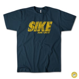 May include: Navy blue t-shirt with the text "SIKE DON'T DO IT" in distressed yellow lettering. The shirt is a classic crew neck style, suitable for casual wear. The design is centered on the front of the shirt.