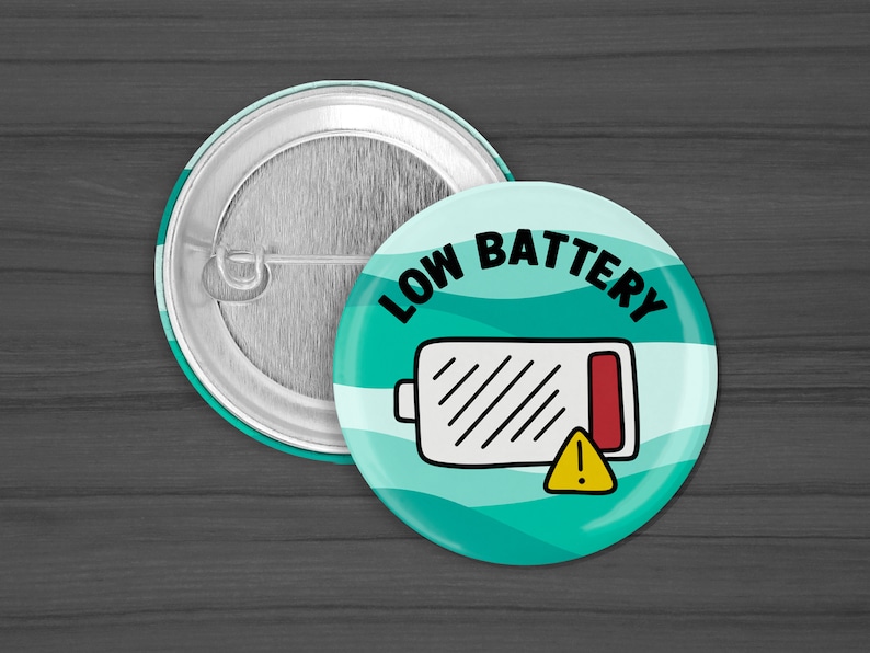 Puede incluir: Un bot&oacute;n a rayas azul turquesa y blanco con el texto "LOW BATTERY" en negro. Un icono de bater&iacute;a blanco con una barra roja y un signo de exclamaci&oacute;n amarillo se encuentra en el centro del bot&oacute;n.