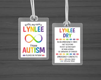 May include: Two white plastic ID cards with rainbow accents. The top card says "Hello, my name is LYNLEE" with a rainbow infinity symbol and the text "I have AUTISM" with the words "PLEASE BE PATIENT" below. The bottom card says "LYNLEE DRY" with the text "IN AN EMERGENCY I MAY: NOT RESPOND, RESIST & RUN AWAY, BE NON-VERBAL, BE UNAWARE OF DANGER" and "EMERGENCY CONTACTS MOM: 123.456.7890 DAD: 123.456.7890".