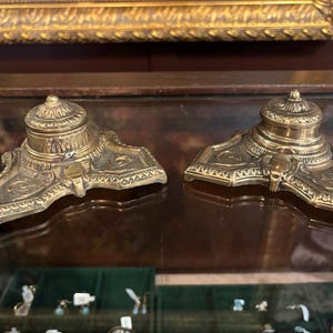 May include: A white ceramic mug with a black handle and the text "But First, Coffee" in a handwritten style. The mug is on a white surface. The mug is 4 inches tall.