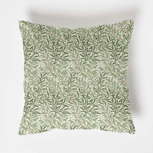 May include: Square throw pillow with a repeating pattern of green willow leaves and branches on a cream background. The leaves vary in shades of green, creating a textured appearance. The pillow is a decorative item for a living room or bedroom.