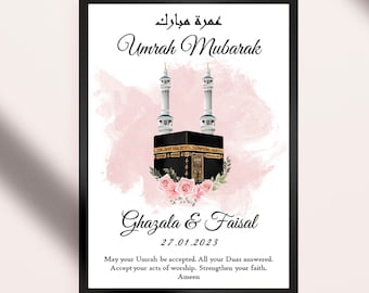 Può includere: Un'illustrazione ad acquerello rosa e bianca della Kaaba, un edificio a forma di cubo a La Mecca, in Arabia Saudita, con due minareti. Il testo "Umrah Mubarak" è scritto in arabo e inglese. I nomi "Ghazala & Faisal" e la data "27.01.2023" sono scritti sotto l'immagine. Il testo "Che la tua Umrah sia accettata. Che tutte le tue Duas siano esaudite. Accetta i tuoi atti di adorazione. Rafforza la tua fede. Amen" è scritto sotto i nomi e la data.