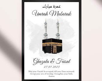 Può includere: Uno sfondo acquerellato bianco e grigio con un'illustrazione in nero e oro della Kaaba, una moschea e il testo arabo "Umrah Mubarak". Sono inclusi anche il testo "Ghazala & Faisal" e la data "27.01.2023". Il testo recita: "Che la tua Umrah sia accettata. Che tutte le tue Duas siano esaudite. Accetta i tuoi atti di adorazione. Rafforza la tua fede. Amen."