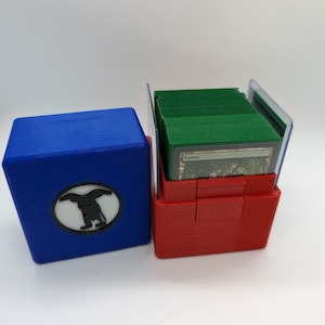 Caja de mazos EDH de Partner Commander para mazos de socios o compañeros. Uno o dos colores con símbolo personalizado. 2 ranuras de carga superior. 100 fundas dobles.