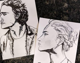 Può includere: Due disegni a inchiostro nero e bianco di volti di persone. Il disegno a sinistra è di una persona con capelli corti e mossi che guarda a sinistra. Il disegno a destra è di una persona con capelli lunghi e mossi che guarda a destra.