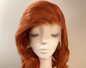 May include: A medium-length, auburn-colored wig with loose waves. The wig is styled with a side part and has a lace front. The wig is on a mannequin head with a black choker necklace.
