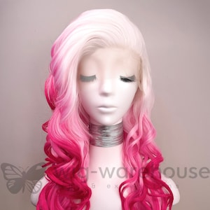 May include: A long, curly wig with a white to pink ombre color. The wig is styled with loose curls and is worn on a mannequin head.