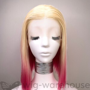 May include: A blonde wig with pink ombre ends. The wig is styled in a straight bob and is on a mannequin head. The wig is labeled "wig-warehouse wigs & extensions".