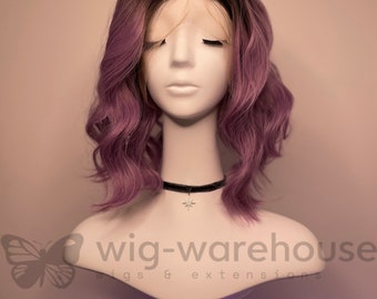 May include: A purple and black wig with loose curls on a mannequin head. The wig is styled in a bob with a side part. The mannequin is wearing a black choker necklace with a star charm. The text "wig-warehouse wigs & extensions" is visible at the bottom of the image.