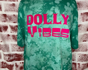 May include: Green tie-dye cropped t-shirt with the words "DOLLY VIBES" in pink lettering.