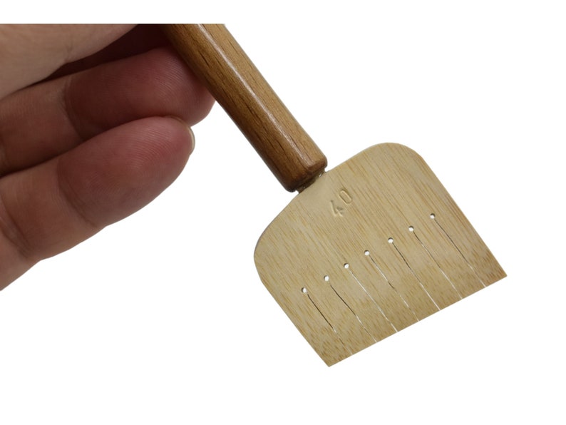 May include: A wooden tool with a handle and a flat, rectangular head with a row of small holes. The head is labeled "4.0".