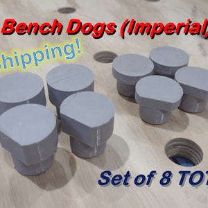 May include: Set of eight gray wooden bench dogs, also known as holdfasts, for woodworking. The text "Bench Dogs (Imperial)" and "Free Shipping!" is visible in the image. The text "Set of 8 TOTAL" is also visible in the image.