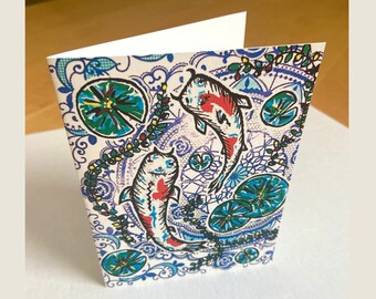 May include: A white card with a colourful design featuring two koi fish swimming in a pond with lily pads and floral patterns.