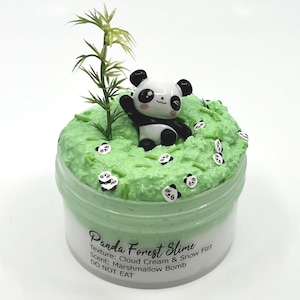 May include: A clear plastic container filled with green slime, decorated with a panda figurine, green sprinkles, and panda-shaped confetti. The text "Panda Forest Slime" is visible on the container.
