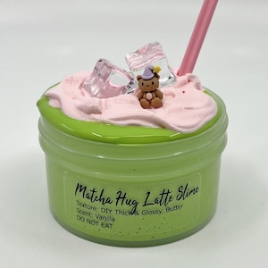 May include: A green jar of Matcha Hug Latte Slime with pink and white toppings, a small bear figurine, and a pink straw. The jar has the text "Matcha Hug Latte Slime" and "DO NOT EAT".
