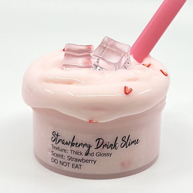 May include: Pink strawberry drink slime with a pink straw and ice cubes. The slime is in a clear container with the text "Strawberry Drink Slime" and "Texture: Thick and Glossy" and "Scent: Strawberry" and "DO NOT EAT".
