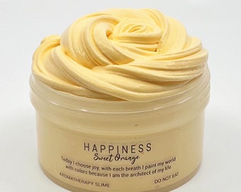 May include: A yellow, sweet orange scented slime in a clear plastic container. The container has a label that reads "HAPPINESS Sweet Orange" and "Today I choose joy, with each breath I paint my world with colors because I am the architect of my life."  The label also reads "AROMATHERAPY SLIME" and "DO NOT EAT".