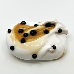May include: White slime with brown swirls and black boba pearls.