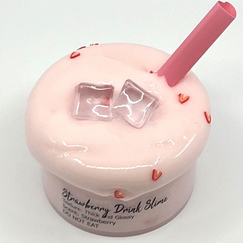 May include: Pink slime with a strawberry scent, thick and glossy texture, in a clear container with a pink straw and ice cubes. The container has a label that reads "Strawberry Drink Slime" and "Do Not Eat".