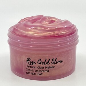 Peut inclure: Un pot transparent rempli de slime rose gold. Le pot est &eacute;tiquet&eacute; "Rose Gold Slime", "Texture : M&eacute;tallique transparente", "Parfum : Non parfum&eacute;" et "NE PAS MANGER".