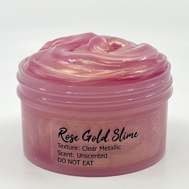 Peut inclure: Un pot transparent rempli de slime rose gold. Le pot est &eacute;tiquet&eacute; "Rose Gold Slime", "Texture : M&eacute;tallique transparente", "Parfum : Non parfum&eacute;" et "NE PAS MANGER".