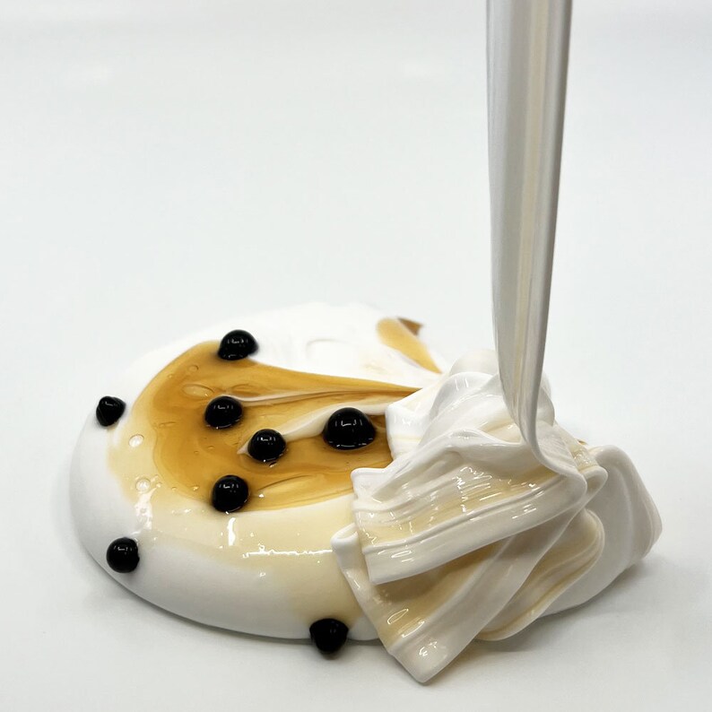 May include: White and brown slime with black boba pearls being poured on top.