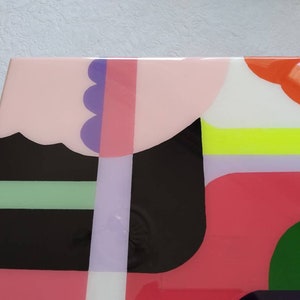 Op de afbeelding: Abstracte geometrische kunstprint met een kleurenschema in roze, zwart, groen, wit, oranje en paars. De print bevat een verscheidenheid aan vormen en patronen.