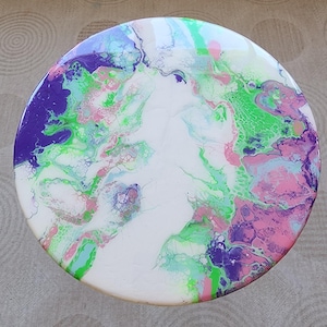 Puede incluir: Pieza de arte redonda de resina blanca con remolinos de pintura verde, púrpura y rosa.