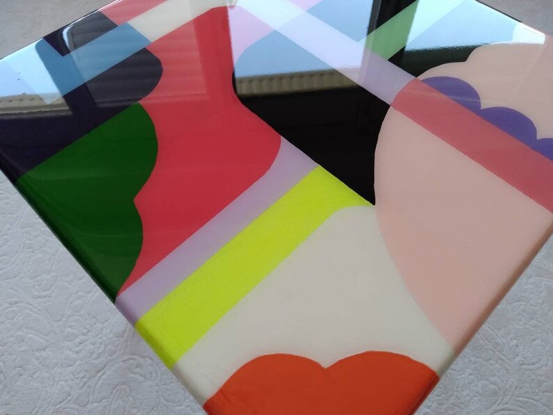 Op de afbeelding: Abstract geometrisch kunstwerk met een glanzende afwerking. Het kunstwerk bevat een verscheidenheid aan kleuren, waaronder roze, groen, geel, wit en zwart. De kleuren zijn gerangschikt in een modern en abstract ontwerp.