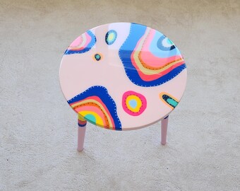 Mesa de centro redonda de resina epoxi rosa: patas pintadas de neón, estilo bohemio pop art.