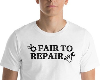 May include: White crew neck t-shirt with the black text "FAIR TO REPAIR", a gear and a wrench graphic. The t-shirt is being worn by a person.