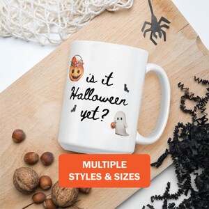 May include: White ceramic mug with the text "is it Halloween yet?" and Halloween-themed illustrations. The mug features a jack-o'-lantern, bats, and a ghost holding a pumpkin. An orange rectangle at the bottom says "MULTIPLE STYLES & SIZES".
