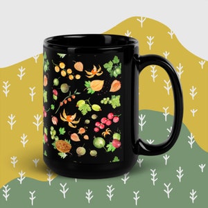 以下が含まれることがあります： 黒いセラミックマグカップ。様々なベリー、葉、花がカラフルに描かれたパターン。赤、緑、オレンジ、黄色の要素が含まれています。マグカップは大きなハンドルと光沢のある仕上がりです。