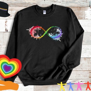 May include: Black crewneck sweatshirt featuring a colorful infinity symbol design. The infinity symbol is rendered in a rainbow gradient with a splatter effect. The sweatshirt is a casual garment.