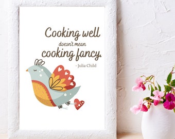 May include: A white framed print featuring a quote by Julia Child: "Cooking well doesn't mean cooking fancy." The quote is accompanied by a colourful illustration of a bird with hearts.