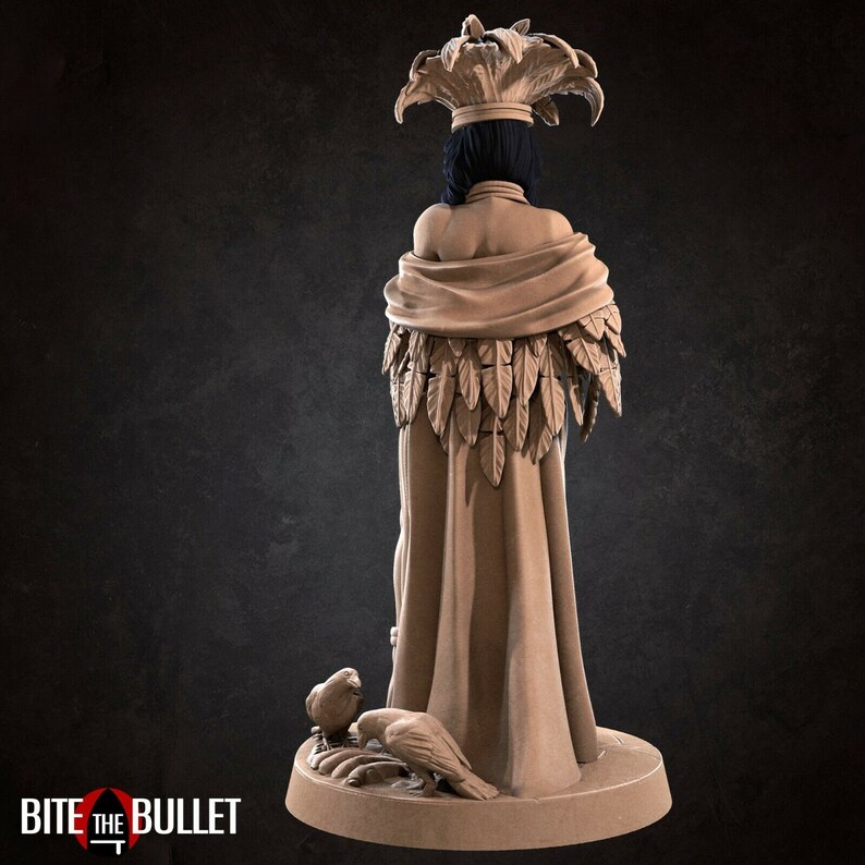 May include: A detailed figurine of a woman wearing a feathered headdress and a long robe with feathers. She is standing on a base with two birds at her feet.