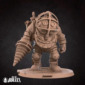 Puede incluir: Figura de color canela de un Big Daddy del videojuego Bioshock. La figura lleva un traje de buceo con un brazo taladro y un casco grande. La base de la figura tiene el texto "Bite the Bullet".