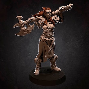 May include: A miniature figurine of a female warrior with red hair, wearing a leather skirt and holding a large axe. The figurine is painted in a brown and tan colour scheme.