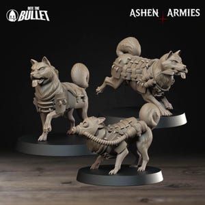 Può includere: Tre figurine di cani grigi con equipaggiamento in stile militare, tra cui imbracature e maschere antigas. Le figurine sono su basi circolari nere. Il testo "Bite the Bullet" e "Ashen Armies" sono visibili.