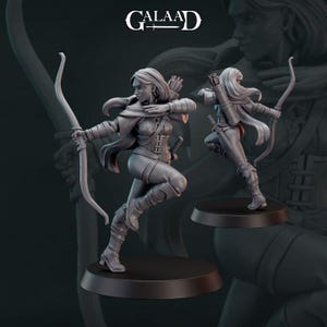 May include: A grey figurine of an archer in a dynamic pose, drawing a bow. The figure is clad in detailed medieval-style clothing, with a quiver on the back. The base is a dark, circular shape. The word "GALAAD" is at the top.