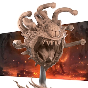 Può includere: Un modello stampato in 3D di un mostro Beholder di Dungeons & Dragons. Il modello è dipinto di un colore marrone chiaro e presenta un grande occhio, una bocca spalancata con denti affilati e tentacoli multipli.