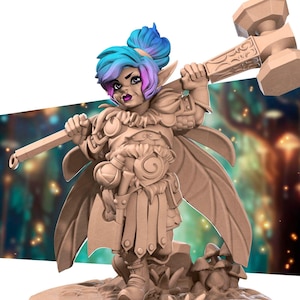 Puede incluir: Una figura miniatura de una guerrera elfa femenina con cabello azul y rosa, vestida con armadura y sosteniendo un gran martillo. La figura está pintada de color marrón claro y está de pie sobre una base con setas.